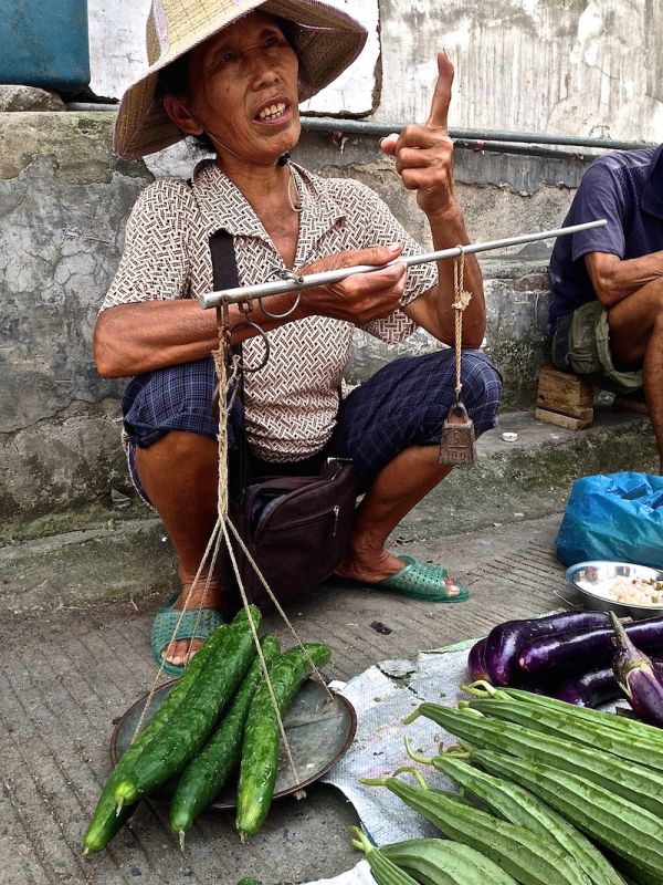 Measuring vegetables the old fashioned way at the Yangshuo local vegetable market